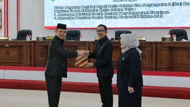 Penjabat Bupati Barito Selatan, Deddy Winarwan menyampaikan dua raperda kepada wakil ketua, Ideham (foto: BorneoToday/HBI)