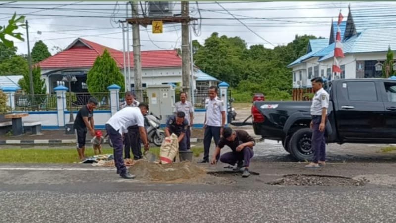 Kepala Dinas Perhubungan Barito Selatan, Joni Priawan bersama stafnya saat memperbaiki lubang jalan (foto: BorneoToday/HBI)